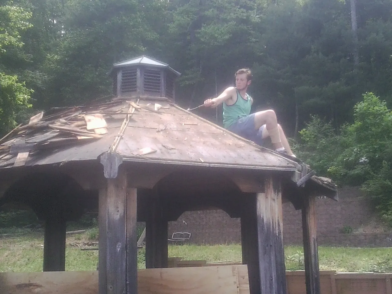 Tearing the old roof off a wooden gazebo before new shakes in White Swan