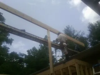 Carpenter setting a ridge beam over a new addition frame — Ice Dam Removal by Roofing Brothers in White Swan
