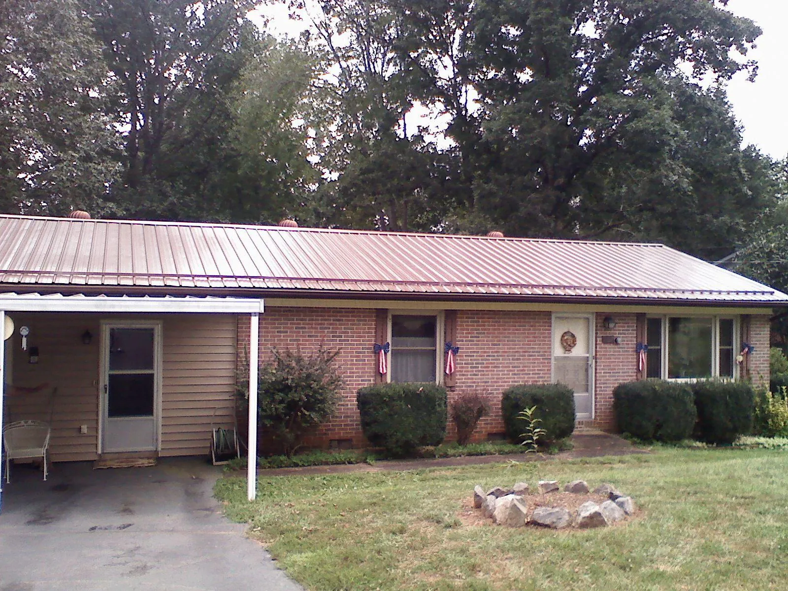 Bronze metal roof and carport on a brick ranch home — Roof Repair work by our crew in White Swan